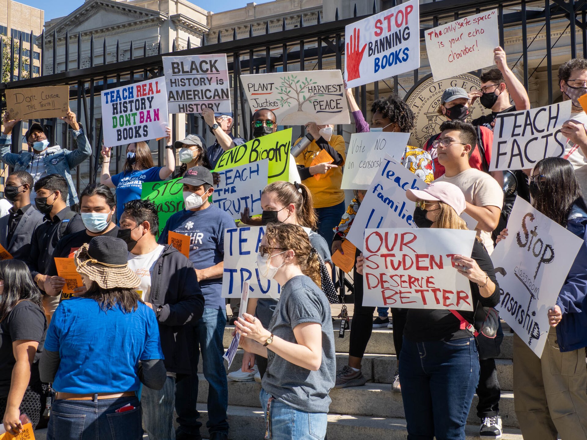 Demonstrators at a book-banning protest holding signs to protect honest history
