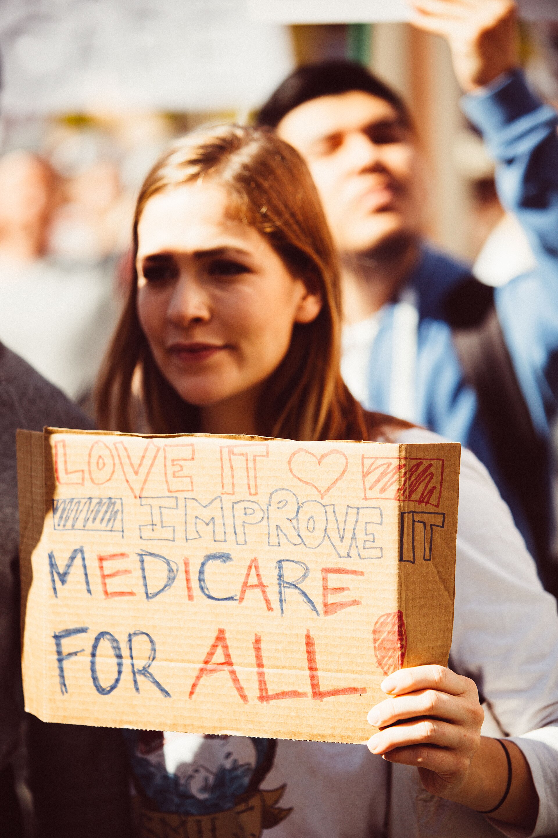 People at a healthcare rally holding signs to protect coverage
